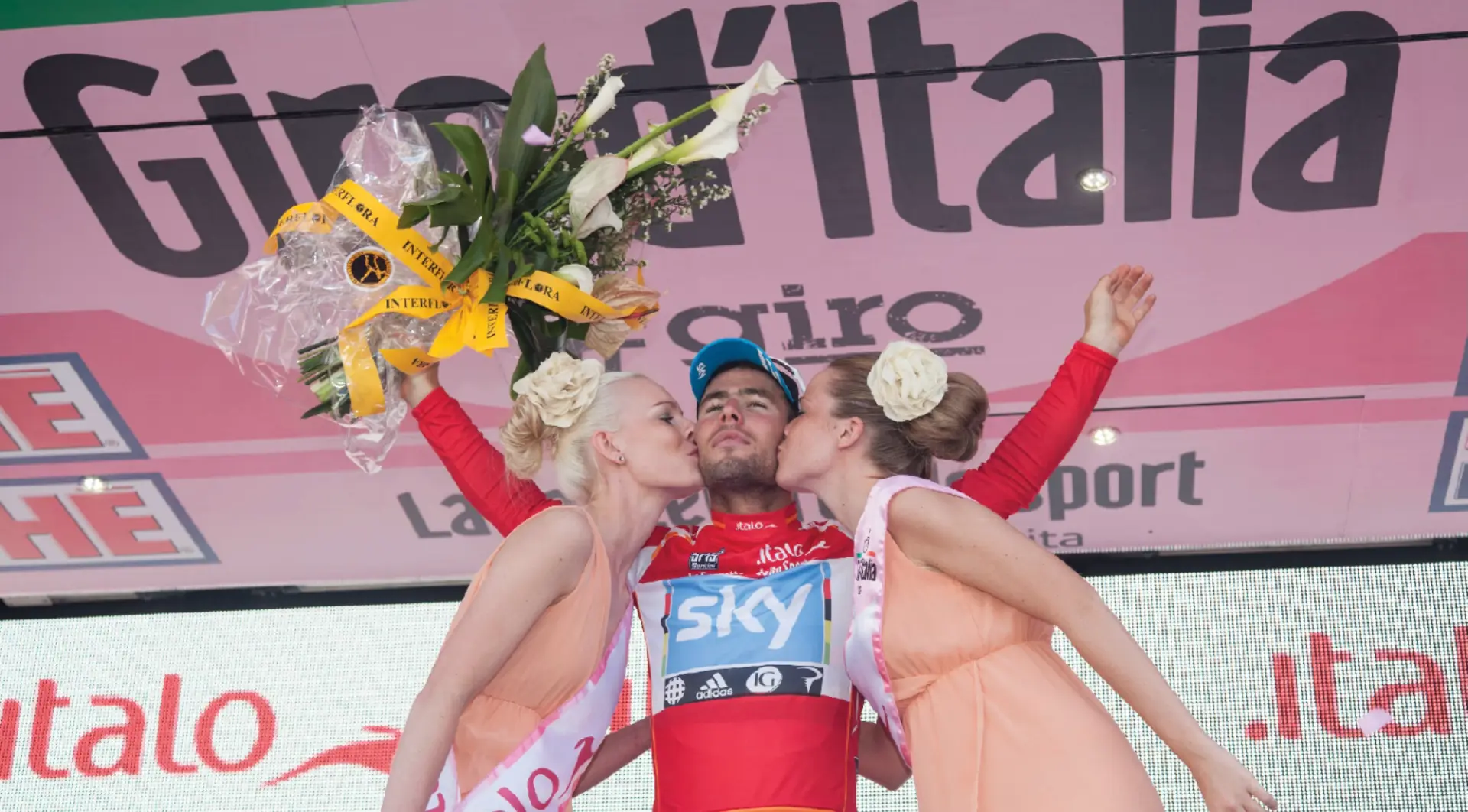 Mark Cavendish on the Giro d'Italia podium in the red points jersey, 2012